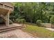Backyard view with brick patio, deck, and stairs leading to the grassy area at 409 Englewood Dr, Chapel Hill, NC 27514