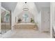 Bright bathroom features a tub under a window, a tiled shower and a modern chandelier at 409 Englewood Dr, Chapel Hill, NC 27514
