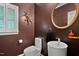 Elegant powder room with a vessel sink, round mirror, and decorative wall art at 409 Englewood Dr, Chapel Hill, NC 27514