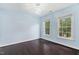 Light blue bedroom with hardwood floors, two large windows, and a modern chandelier at 409 Englewood Dr, Chapel Hill, NC 27514