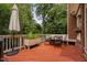 Spacious wood deck with outdoor dining area, umbrella and lush green surroundings providing a peaceful retreat at 409 Englewood Dr, Chapel Hill, NC 27514