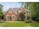 Charming two-story brick home with arched windows, a well-maintained lawn, and mature landscaping at 409 Englewood Dr, Chapel Hill, NC 27514