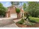 Side view of a stately brick home featuring an attached garage, and a landscaped yard at 409 Englewood Dr, Chapel Hill, NC 27514
