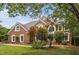 Beautiful brick home featuring manicured landscaping, architectural design, and large windows at 409 Englewood Dr, Chapel Hill, NC 27514