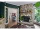 Charming living room featuring a stone fireplace and an open doorway to the kitchen at 409 Englewood Dr, Chapel Hill, NC 27514