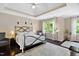 Comfortable main bedroom with a tray ceiling, ceiling fan, and large windows for natural light at 409 Englewood Dr, Chapel Hill, NC 27514