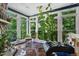 Bright sunroom with large windows offering scenic views and a cozy seating area at 409 Englewood Dr, Chapel Hill, NC 27514