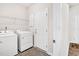 Functional laundry room with washer, dryer, storage shelf, and access to the exterior at 4102 Catfish Way, Durham, NC 27703