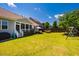 Expansive backyard featuring a lush lawn, screened porch, hammock, swing set, and plenty of space for outdoor activities at 42 Juneberry Dr, Chapel Hill, NC 27516