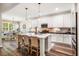 Bright kitchen featuring white cabinetry, subway tile backsplash, and a central island with bar stool seating at 42 Juneberry Dr, Chapel Hill, NC 27516