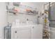 Functional laundry area with white washer and dryer, storage shelves, and water heater at 435 Summerwalk Cir # 435, Chapel Hill, NC 27517