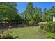 Lush backyard featuring green grass and landscaping with a wrought iron fence at 453 Panorama Park Pl, Cary, NC 27519