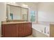 Bathroom features a double vanity, garden tub, tile accents, and large mirror at 453 Panorama Park Pl, Cary, NC 27519