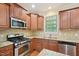 Well-equipped kitchen features stainless steel appliances, granite countertops, and wooden cabinetry at 453 Panorama Park Pl, Cary, NC 27519