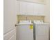 Functional laundry room with white washer, dryer, and overhead cabinets at 453 Panorama Park Pl, Cary, NC 27519