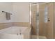 Bathroom featuring a soaking tub and a shower with glass doors and tile surround at 4533 Pale Moss Dr, Raleigh, NC 27606