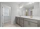 Bright bathroom boasts double vanity with gray cabinetry and quartz counters at 4716 Crescent Square St # 1314, Raleigh, NC 27616