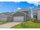 Side exterior featuring an attached two-car garage, dark siding, and green lawn at 4716 Crescent Square St # 1314, Raleigh, NC 27616