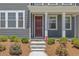Covered front porch with stone steps and a modern front door at 4716 Crescent Square St # 1314, Raleigh, NC 27616