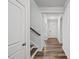 Hallway view showcasing hardwood floors and a staircase at 4716 Crescent Square St # 1314, Raleigh, NC 27616