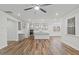 Open-concept living space with kitchen, wood floors, ceiling fan, and abundant natural light at 4716 Crescent Square St # 1314, Raleigh, NC 27616