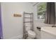 Bright bathroom featuring a toilet, storage unit, sink and window at 500 Ellen Dr, Knightdale, NC 27545