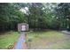 Spacious backyard with a small storage shed and manicured lawn at 5112 Stephens Ln, Durham, NC 27712