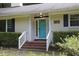 Inviting front entrance with a bright blue door, white trim, and manicured landscaping at 5112 Stephens Ln, Durham, NC 27712