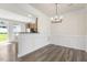 Open dining area featuring decorative chair rail, modern chandelier, and dark wood-look floors at 523 Berry Chase Way, Cary, NC 27519