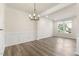 Bright dining room with crown molding, dark wood-look floors and modern chandelier at 523 Berry Chase Way, Cary, NC 27519