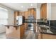 Well-lit kitchen featuring stainless steel appliances, granite countertops, and wooden cabinets at 523 Berry Chase Way, Cary, NC 27519