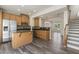 Modern kitchen with stainless steel appliances, wooden cabinets, and granite countertops overlooking the living area at 523 Berry Chase Way, Cary, NC 27519