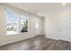 Bright living room featuring large windows, modern gray flooring, and crisp, clean walls at 523 Berry Chase Way, Cary, NC 27519