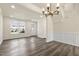 Open-concept living room featuring dark wood-look flooring, with crown molding, and large windows at 523 Berry Chase Way, Cary, NC 27519