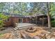 Beautiful backyard features a stone fire pit, deck, screened porch, and lush landscaping at 5315 Mccormick Rd, Durham, NC 27713