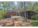 Exterior of house featuring a fire pit, wooden deck, and screened in porch nestled within mature trees at 5315 Mccormick Rd, Durham, NC 27713