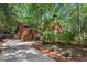 Wooded exterior view showcasing the home's driveway, front facade, and chimney at 5315 Mccormick Rd, Durham, NC 27713