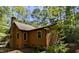 Exterior view showcasing wood siding, updated windows, brick chimney, and lush greenery surrounding the home at 5315 Mccormick Rd, Durham, NC 27713