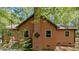 Side exterior of the home featuring wood siding, a brick chimney, and well-maintained landscaping at 5315 Mccormick Rd, Durham, NC 27713