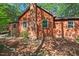 Cozy single-Gathering home featuring a brick chimney and brown siding, nestled amongst leafy trees at 5315 Mccormick Rd, Durham, NC 27713