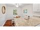 Kitchen with an eat-in dining area, featuring white cabinets, granite countertops, and wood floors at 5315 Mccormick Rd, Durham, NC 27713