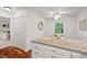 An eat-in kitchen featuring wood floors, granite countertops, and white cabinets at 5315 Mccormick Rd, Durham, NC 27713