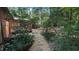 Stone pathway through lush landscaping leads to backyard structures, adding to the property's charm at 5315 Mccormick Rd, Durham, NC 27713
