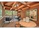 Screened-in porch with dining and seating areas, wood ceiling beams, and access to the home office at 5315 Mccormick Rd, Durham, NC 27713