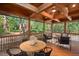 Open and airy screened porch featuring a dining area, comfortable lounge seating, and serene wooded views at 5315 Mccormick Rd, Durham, NC 27713