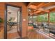 Covered outdoor porch featuring wood ceiling and beams, comfortable seating, and access to the main house at 5315 Mccormick Rd, Durham, NC 27713
