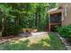A serene backyard features a charming patio, surrounded by lush trees, and outdoor furniture, perfect for relaxation at 553 Lake Gaston Dr, Fuquay Varina, NC 27526