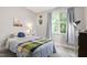 Bedroom with a full-size bed with side table and lamp, a window view, and a decorative wall hanging at 553 Lake Gaston Dr, Fuquay Varina, NC 27526