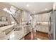 Bright kitchen boasts granite countertops, stainless steel appliances, and connects to a staircase at 553 Lake Gaston Dr, Fuquay Varina, NC 27526