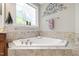 Bright soaking tub features decorative tile surround and decorative window allowing natural light at 553 Lake Gaston Dr, Fuquay Varina, NC 27526